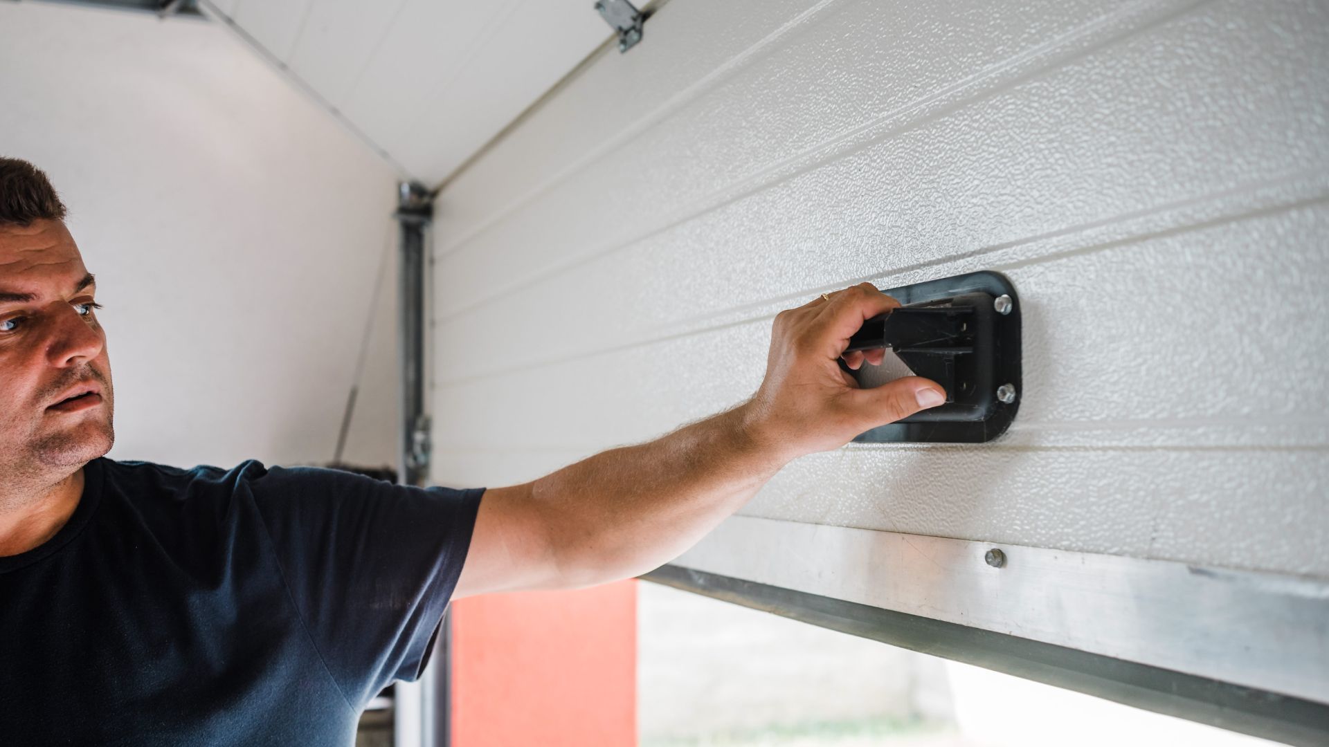 Person adjusting or fixing a wall-mounted device in a garage