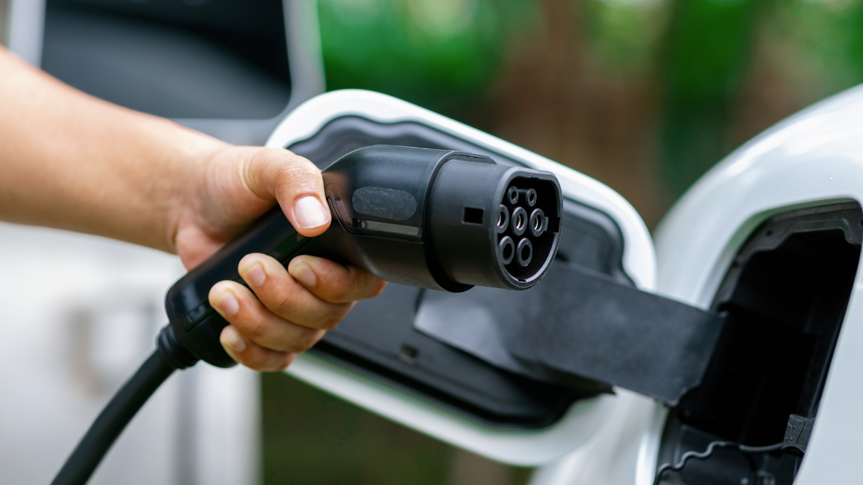 A person pumping gas into a white car