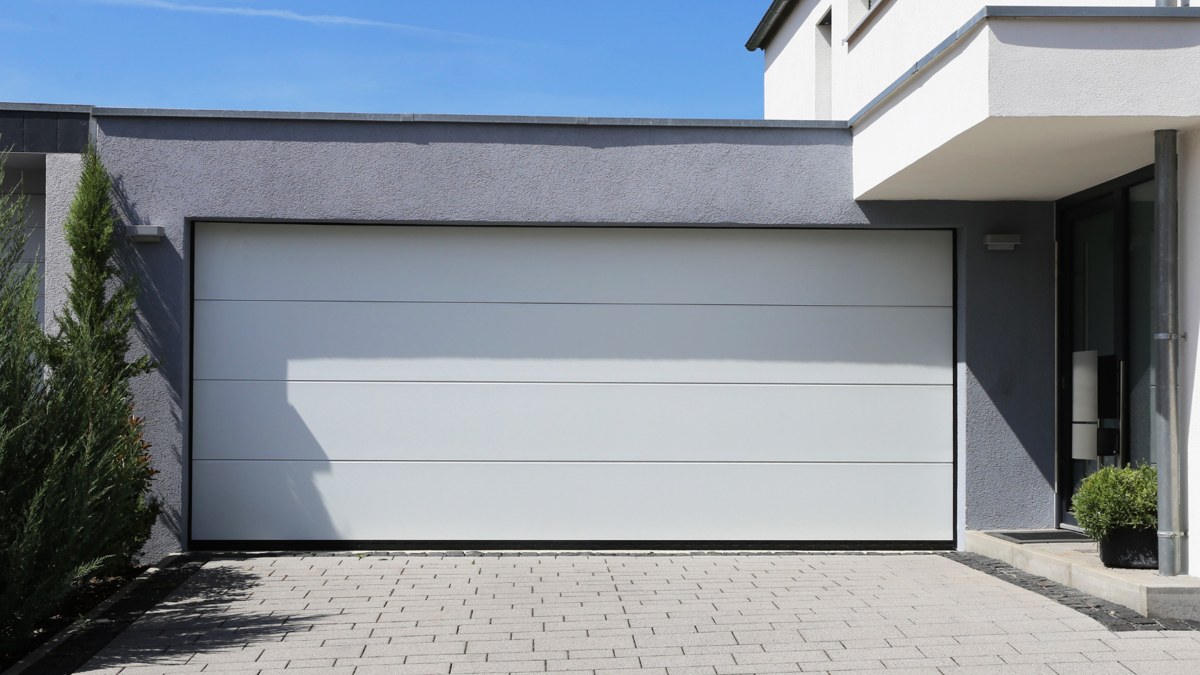 A white garage door in front of a house