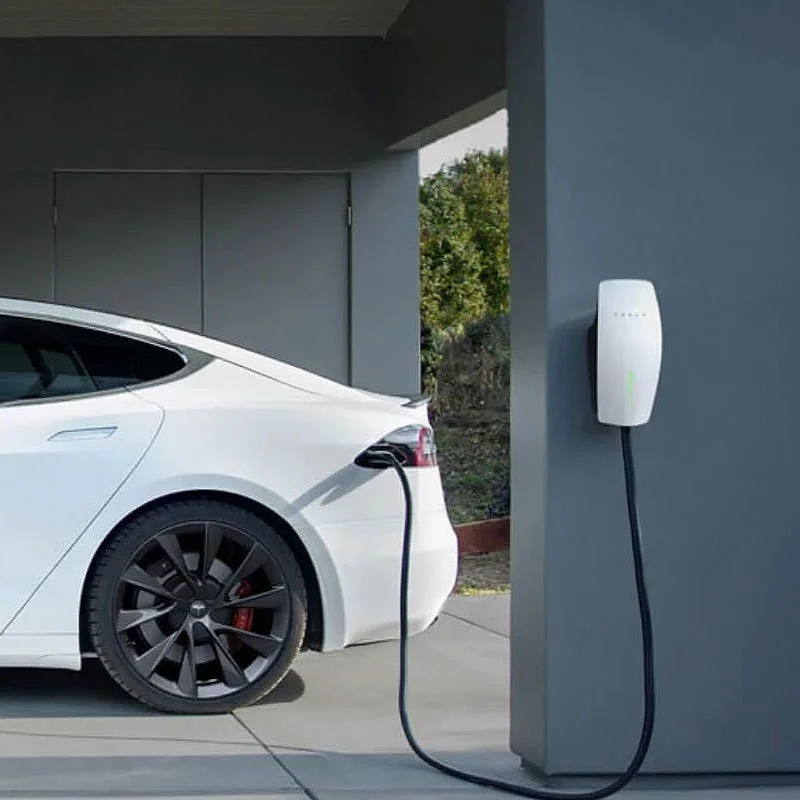 A white electric car plugged in to a charging station